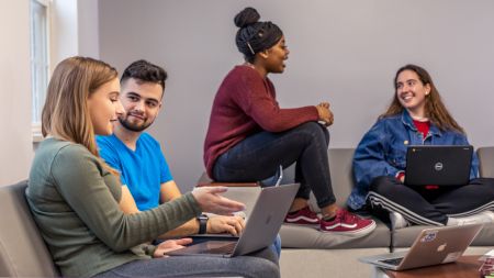 Students in residence hall lounge studying with each other
