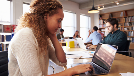 Student working on laptop in library
