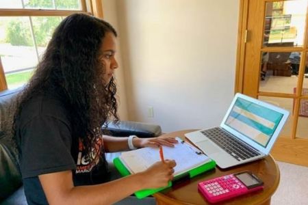 High school student participates in virtual summer camp on laptop