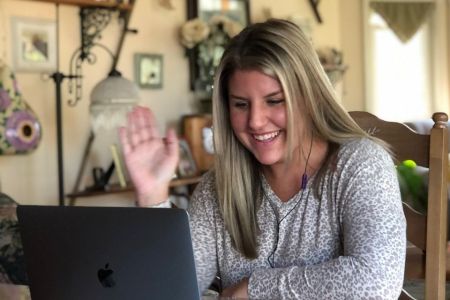 Samantha Begley waves to her computer as she meets with a group of incoming business students.
