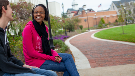 Two students sitting outside Widener's library in the fall