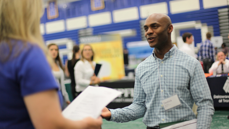 Student at Widener career fair talking through resume with prospective employer