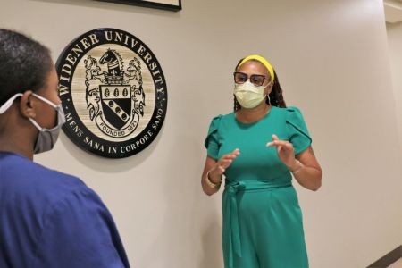 Black female professor engages with a Black female nursing student.