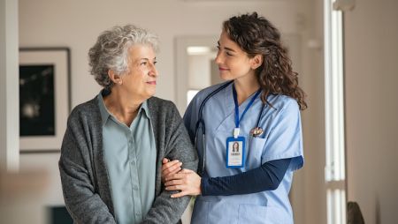 BSN Nursing Major Helps Older Patient in Medical Setting