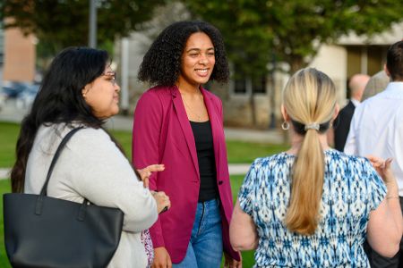 Student Donya Moore talks to other people at an outdoor School of Business conference