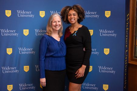 Donya Moore and President Robertson standing in front of a Widener backdrop