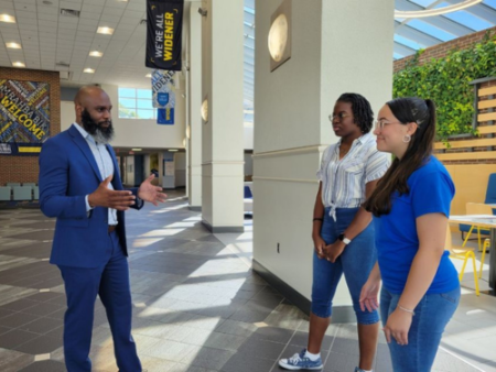 Fred McCall and two students talk in the University Center atrium