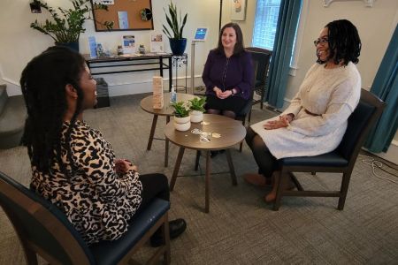 Three seated women talking in the CAPS office