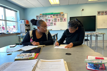 A Widener student and an Egdmont student in a tutoring session together in a classroom setting