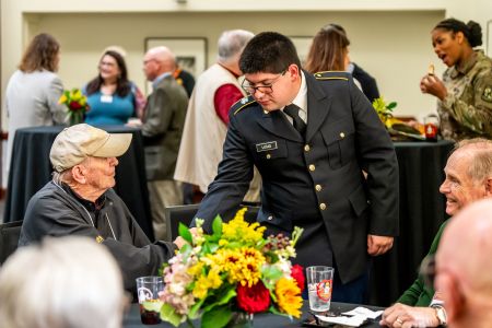 Luis Lucas in dress blues talks with a PMC alumnus