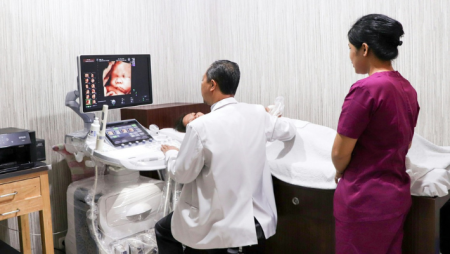 A diagnostic medical sonography student and medical professional perform an ultrasound.