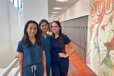PA students female scrubs ACN 960 x 640 Three female PA students in scrubs stand together for a photo.
