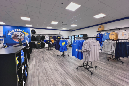 Interior of campus store with shirts, sweatshirts, and other swag on display for purchase