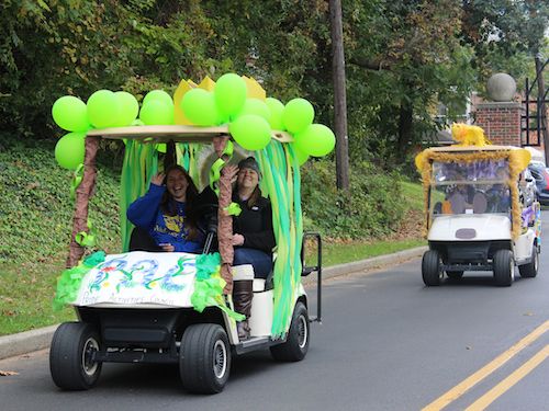 students drive in decorated golf carts at homecoming