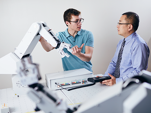 Robotics engineering student and faculty in robotics lab