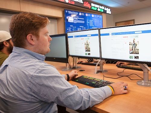 Finance student working on multiple monitors in finance lab