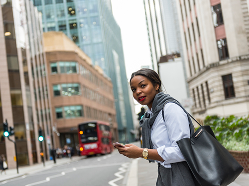 International business student/professional 500x375 Dressed up business professional with phone walking in London