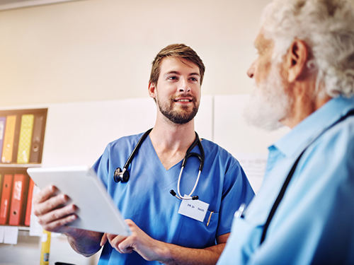 Nurse giving update to adult patient in exam room