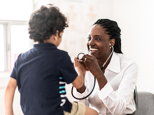 Pediatric nurse caring for young patient in exam room