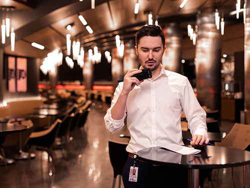 Event management alumnus on walkie talkie in concourse of Wells Fargo center in Philadelphia