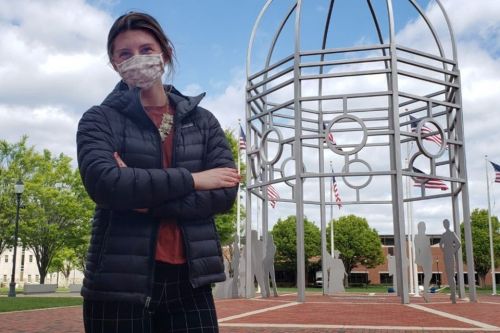 Student Julia Klinger standing alone in the Bown Garden with the dome behind her.