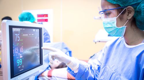critical aute care nurse reads ICU monitor
