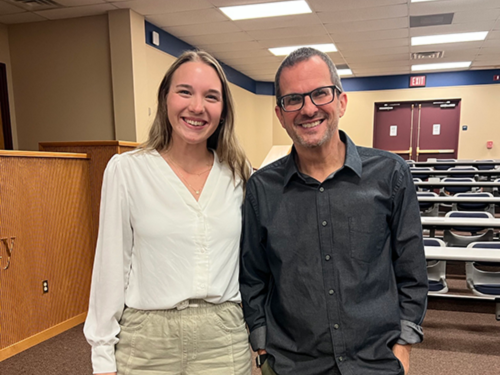 A student and faculty member pose together for a photo