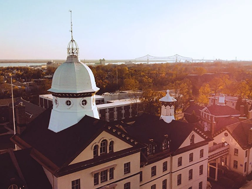 Aerial view of Old Main and the dome bathed in a golden light from a sunset