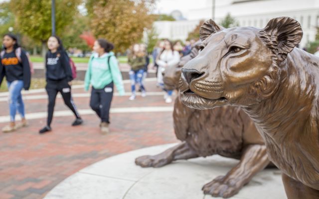 Students walking by Pride Statue 