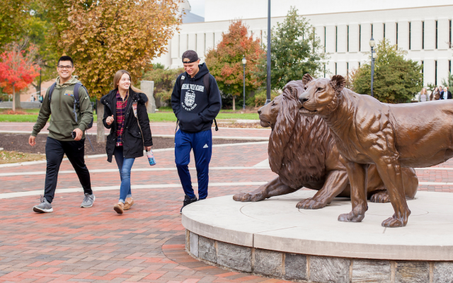 Students walking past Pride statues on Widener Campus