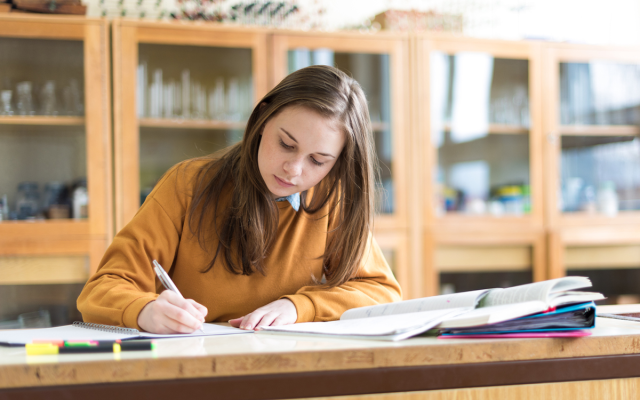 Student taking notes in science lab setting