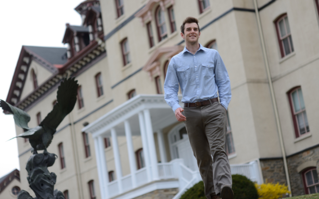 A business student stands outside of Old Main on Widener University's campus.