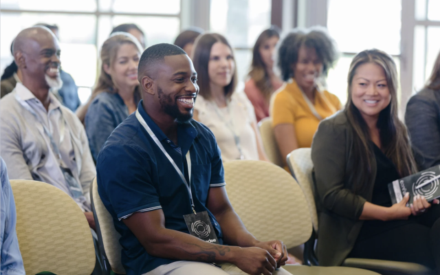 group of people sitting in the audience at a conference