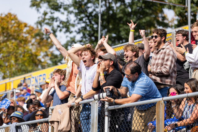 Passionate fans cheer on the Pride from the stands at the football game.