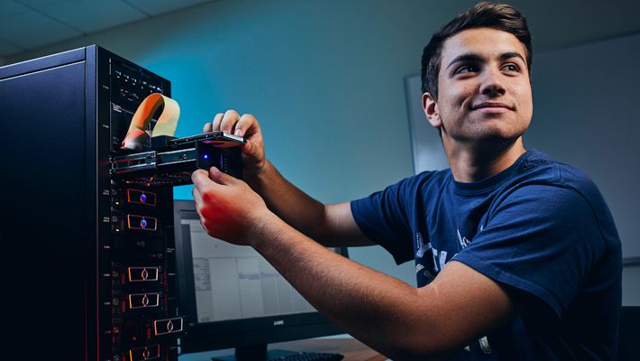 Computer Science Student in Classroom with Hard Drive