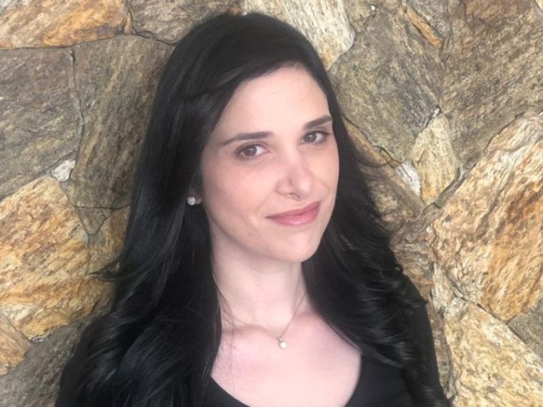 Karina Brasil stands in front of stone wall