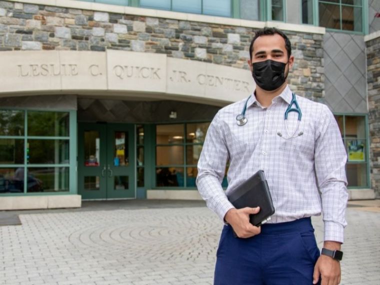 Jason Beiriger stands in front of Quick Center with a stethoscope around his neck