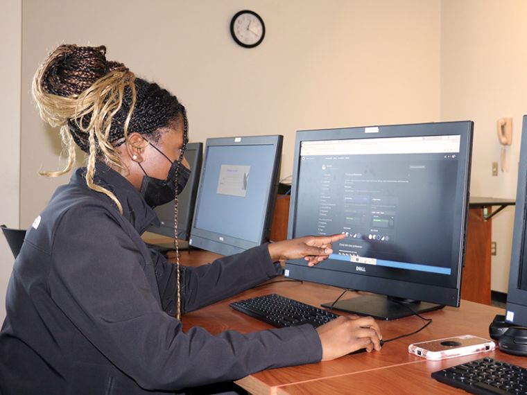 Desiree Junfijiah points to a computer screen she's working on