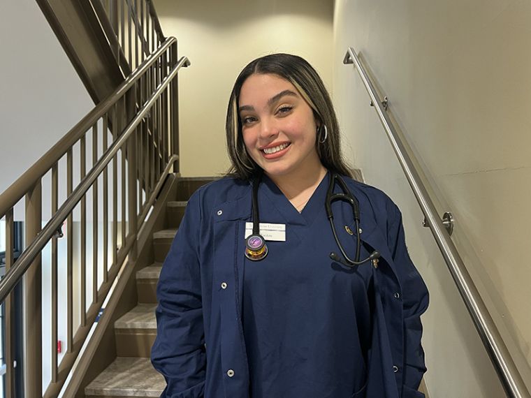 Nursing student Maritza Garcia poses in blue Widener scrubs
