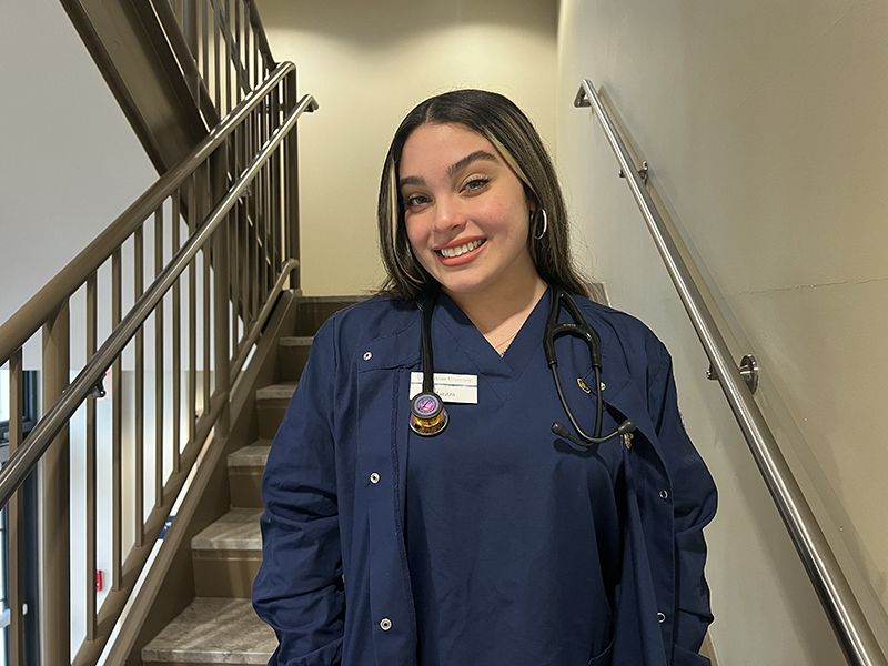 Nursing student Maritza Garcia poses in blue Widener scrubs