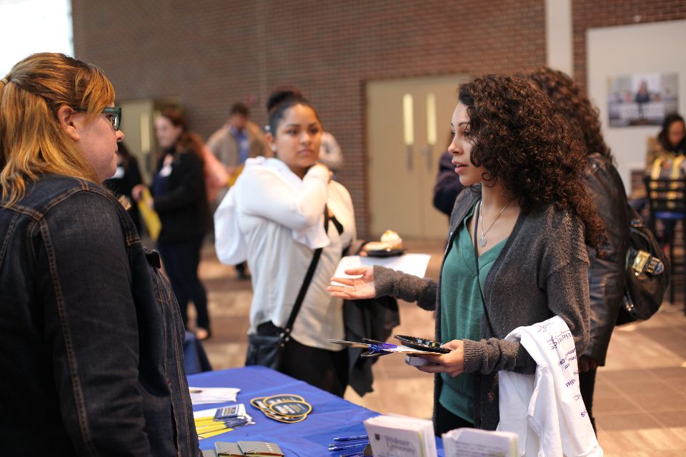 student asking questions at extended learning open house