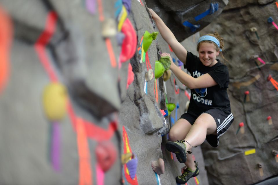 student climbs rock wall at pride recreation center