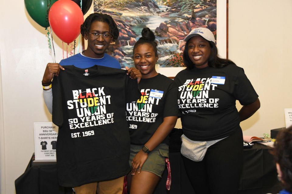 Black Student Union 50th anniversary celebration with 3 students wearing or holding commemorative T-shirts