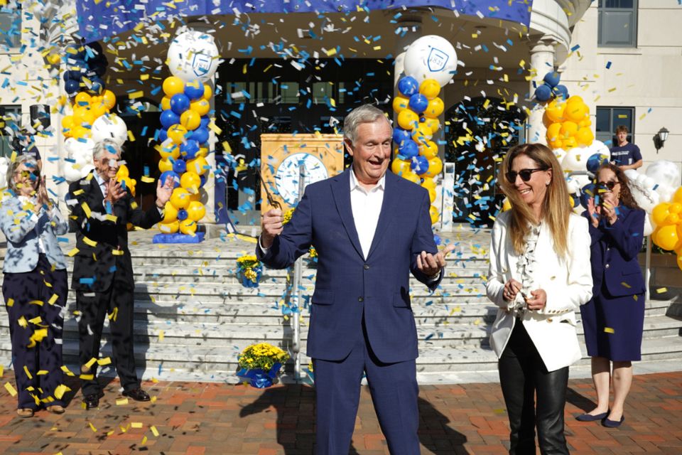 Jack and Nancy Dwyer smile as they cut the ribbon and confetti flies to unveil the Jack & Nancy Dwyer School of Nursing.