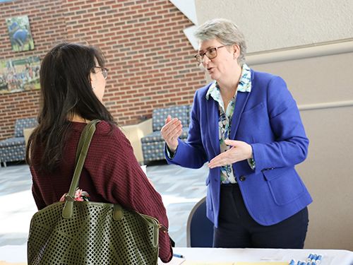 student talks with faculty at open house